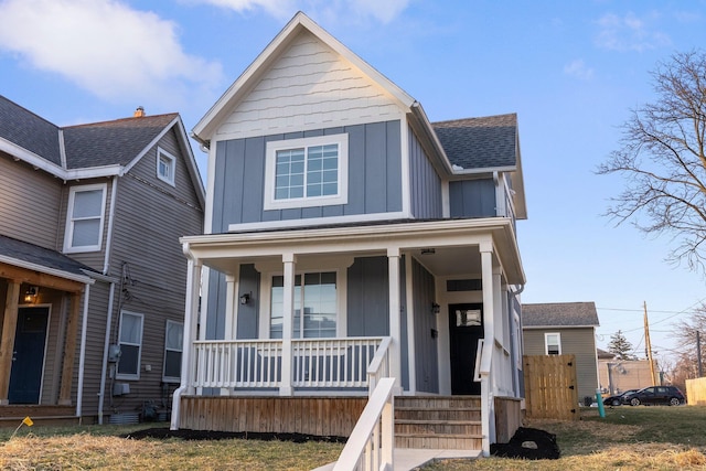 view of front facade featuring covered porch, board and batten siding, and a shingled roof