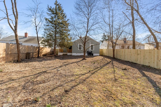 view of yard with central AC unit and a fenced backyard