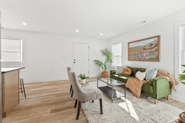 living area featuring visible vents, recessed lighting, light wood-type flooring, and baseboards