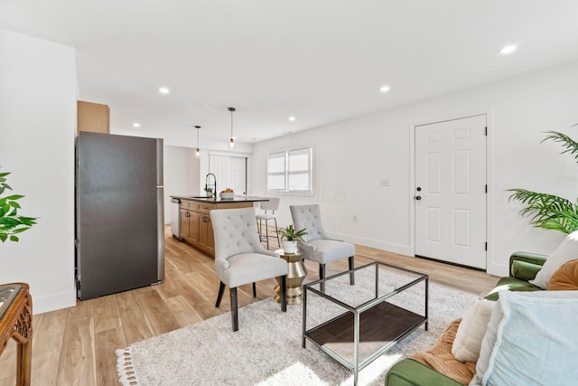 living room featuring recessed lighting, light wood-style floors, and baseboards