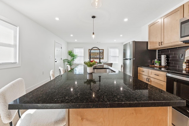 kitchen with plenty of natural light, tasteful backsplash, appliances with stainless steel finishes, and a sink