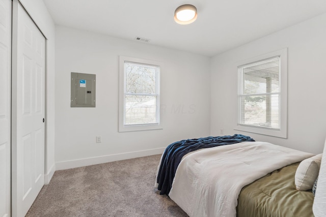 carpeted bedroom featuring multiple windows, electric panel, baseboards, and visible vents