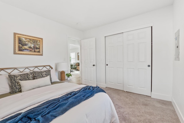 bedroom featuring electric panel, baseboards, a closet, and light carpet