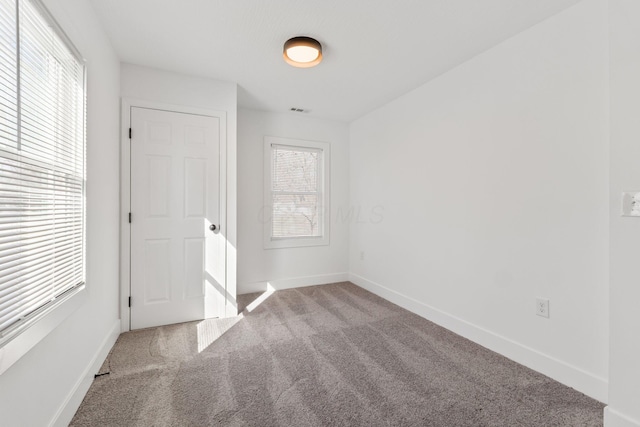 unfurnished bedroom with visible vents, baseboards, and carpet flooring