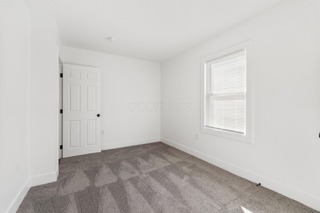 unfurnished room featuring carpet flooring and baseboards