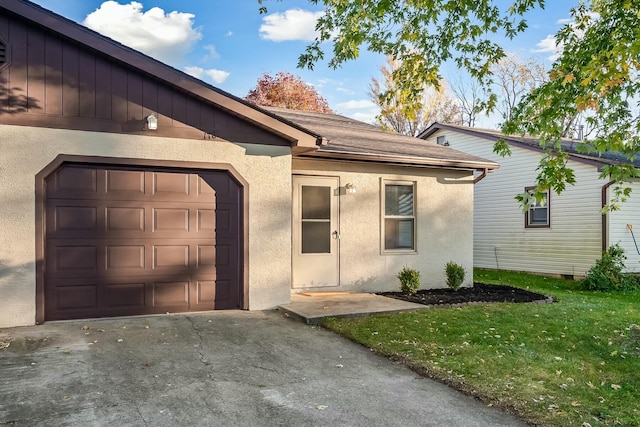 view of front facade featuring stucco siding, driveway, an attached garage, and a front lawn