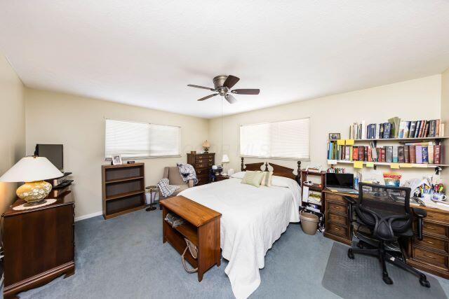 bedroom with a ceiling fan and carpet