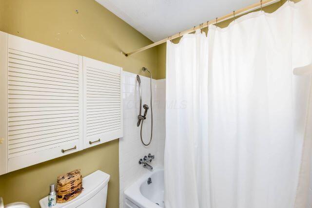 bathroom featuring toilet and shower / bath combo