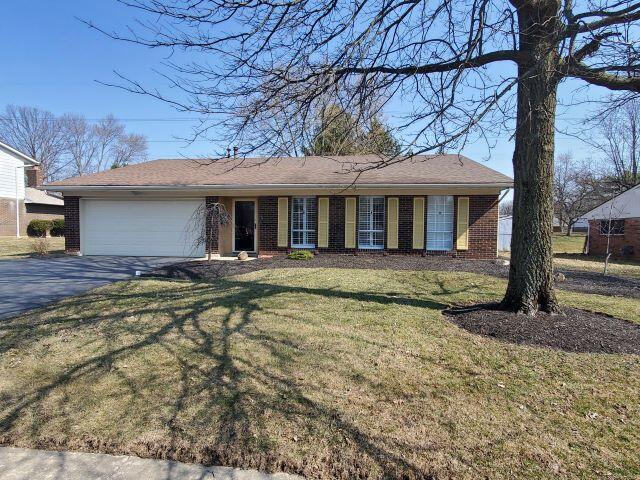 single story home featuring a garage, a front yard, brick siding, and driveway