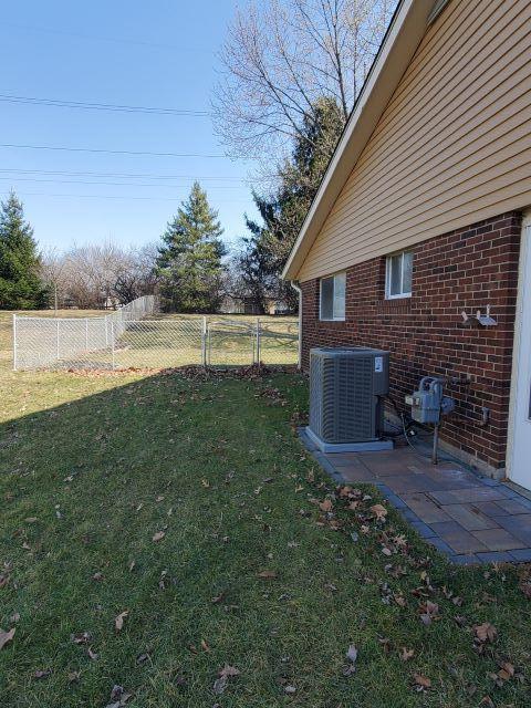 view of yard featuring central AC unit and fence