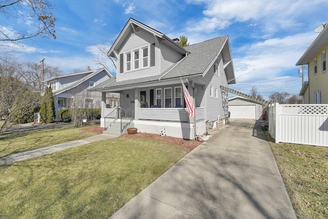 bungalow with an outbuilding, a front lawn, fence, roof with shingles, and covered porch