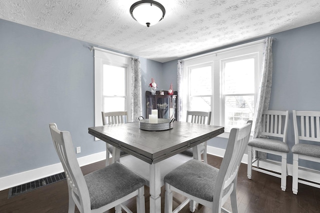 dining room with wood finished floors, baseboards, and a textured ceiling