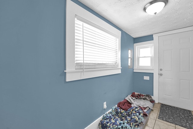 foyer entrance featuring tile patterned flooring and a textured ceiling