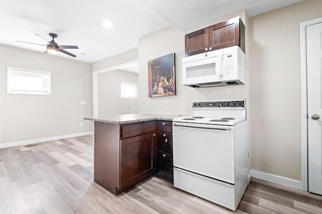 kitchen featuring white appliances, dark brown cabinetry, a peninsula, and a healthy amount of sunlight