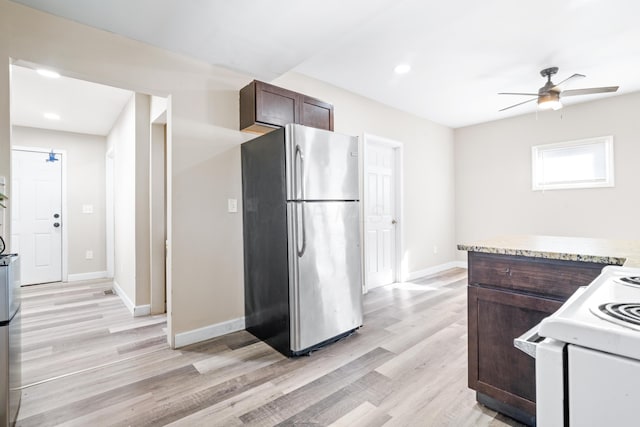 kitchen with baseboards, freestanding refrigerator, dark brown cabinetry, light wood-style floors, and white electric range