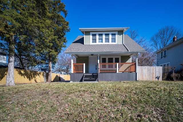 bungalow-style house featuring a porch, fence, a front yard, and a shingled roof