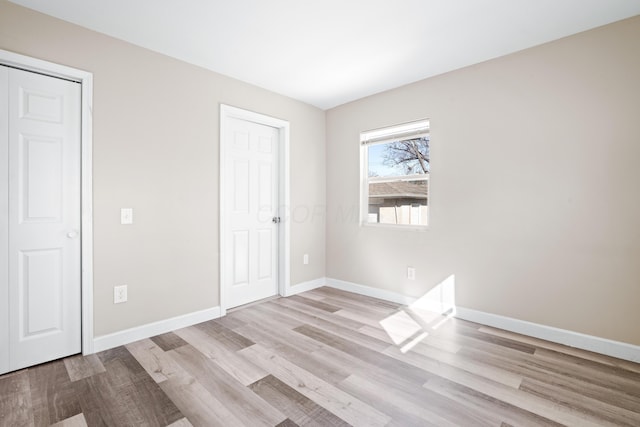 unfurnished bedroom featuring baseboards and wood finished floors