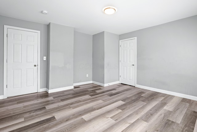 unfurnished room with baseboards and wood finished floors