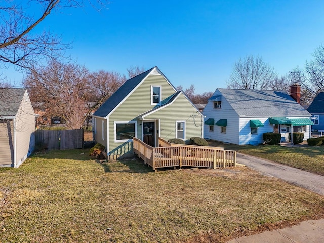 view of front of house featuring a wooden deck, a front yard, and fence