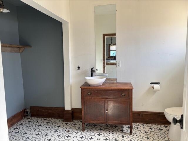 bathroom featuring vanity, tile patterned floors, toilet, and baseboards