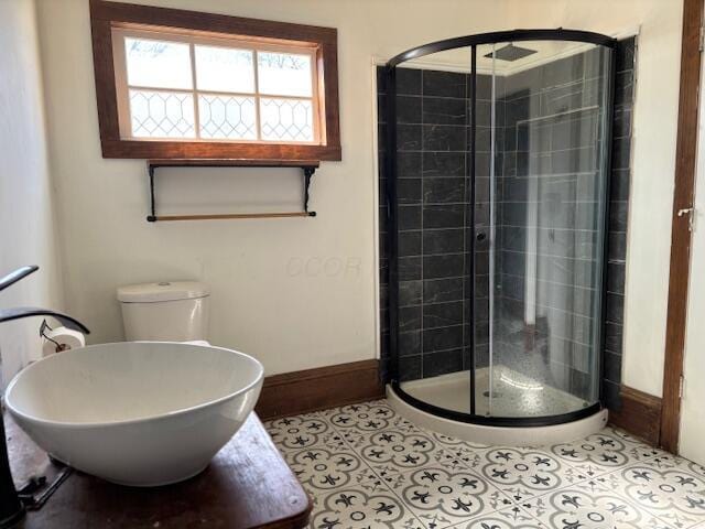 bathroom featuring baseboards, a stall shower, and tile patterned flooring