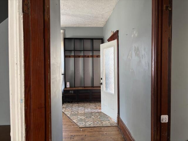 hallway featuring wood finished floors and a textured ceiling