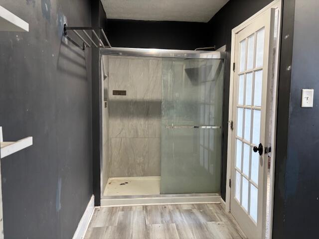 bathroom with a healthy amount of sunlight, wood finished floors, and walk in shower