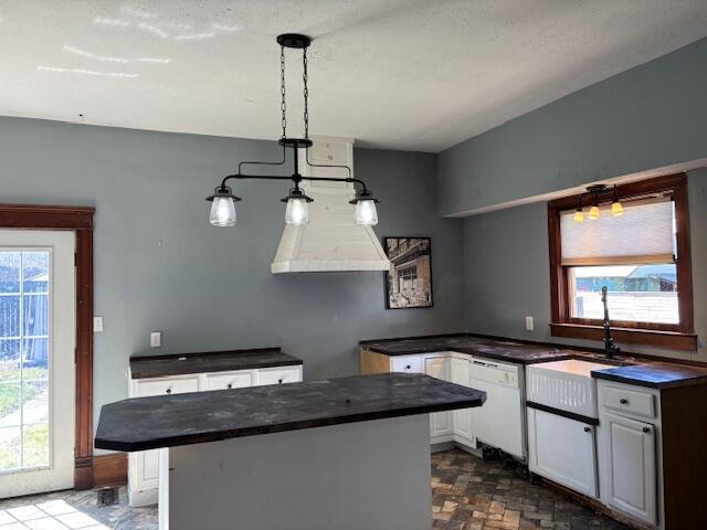 kitchen featuring a sink, dark countertops, dishwasher, and a wealth of natural light