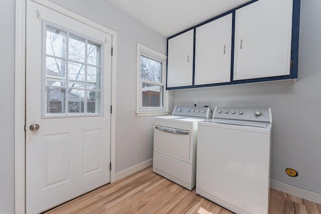 laundry room with cabinet space, light wood-type flooring, baseboards, and separate washer and dryer