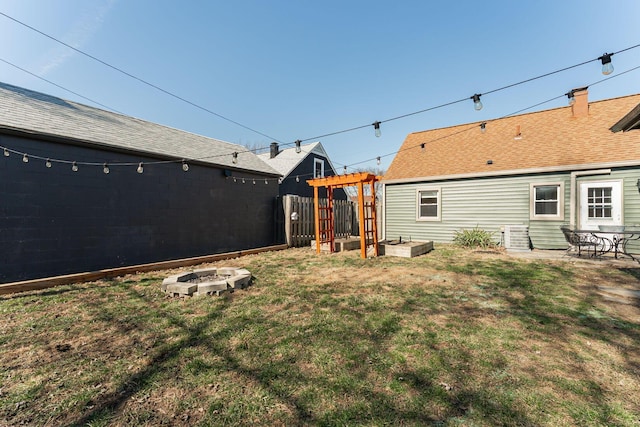 view of yard featuring an outdoor fire pit, a vegetable garden, and fence