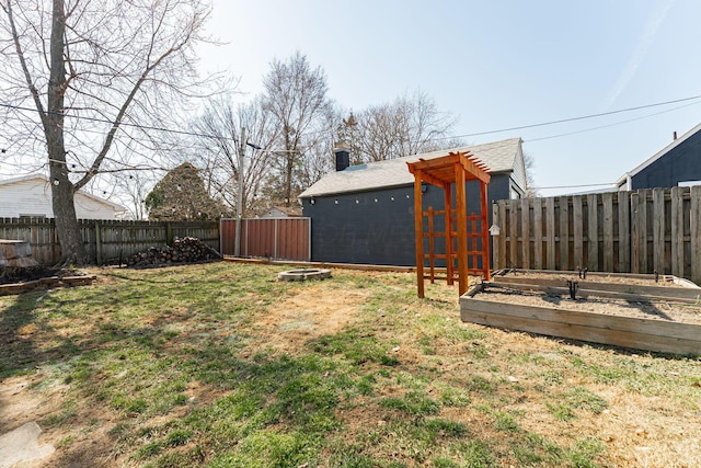 view of yard featuring a garden and a fenced backyard