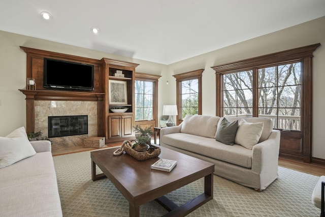 living area featuring recessed lighting, a fireplace, and light wood finished floors