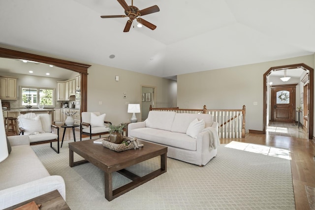 living room featuring light tile patterned floors, a ceiling fan, recessed lighting, arched walkways, and vaulted ceiling