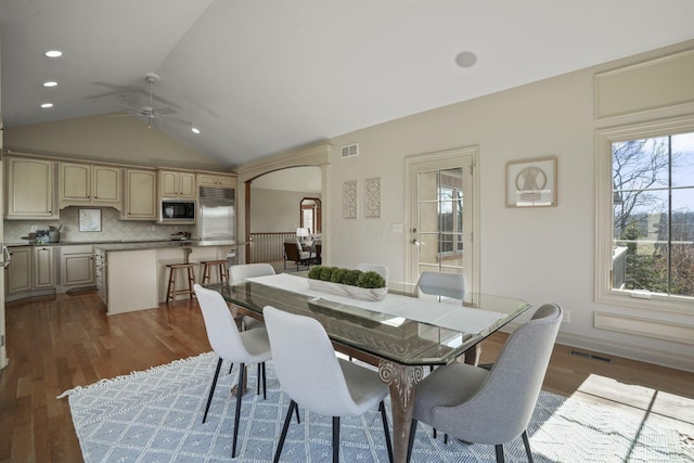 dining space with visible vents, lofted ceiling, and dark wood-style flooring