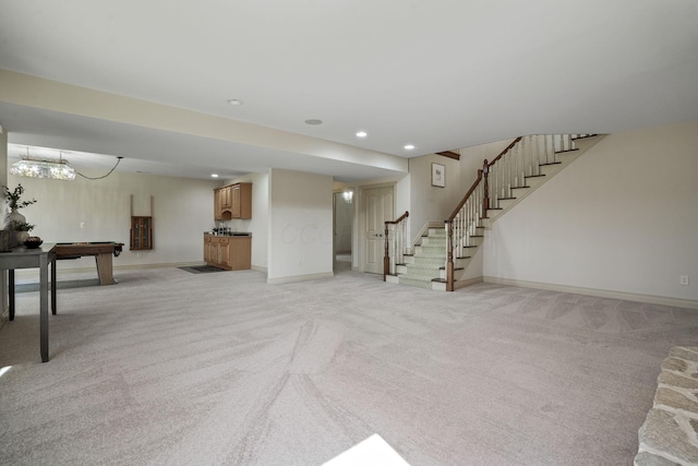 below grade area with stairway, baseboards, an inviting chandelier, recessed lighting, and light carpet