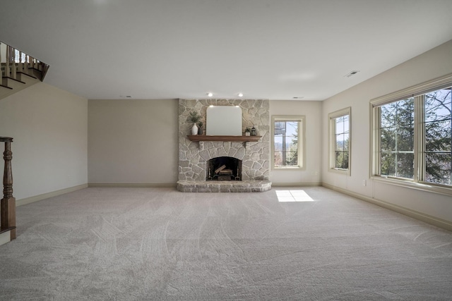 unfurnished living room featuring visible vents, carpet floors, baseboards, and a fireplace