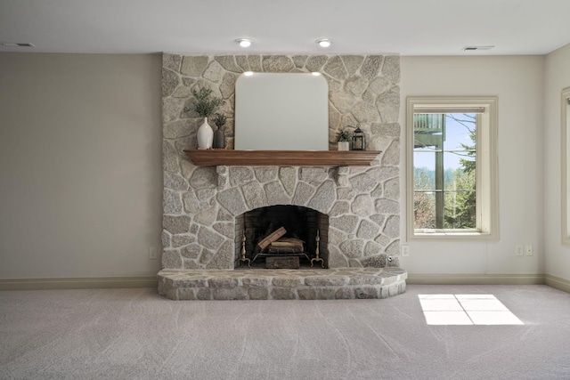 unfurnished living room with a stone fireplace, visible vents, baseboards, and carpet