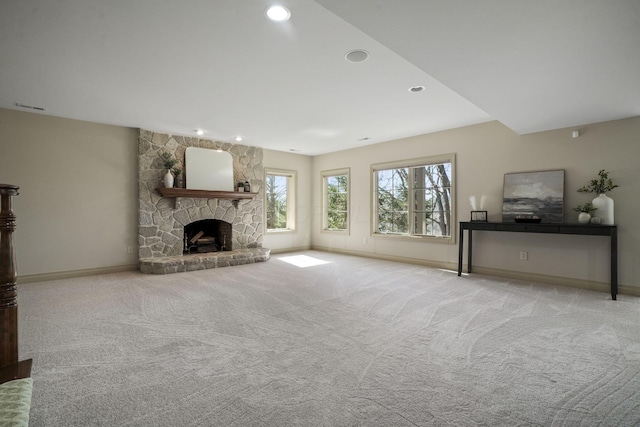 unfurnished living room featuring a stone fireplace, recessed lighting, baseboards, and carpet floors