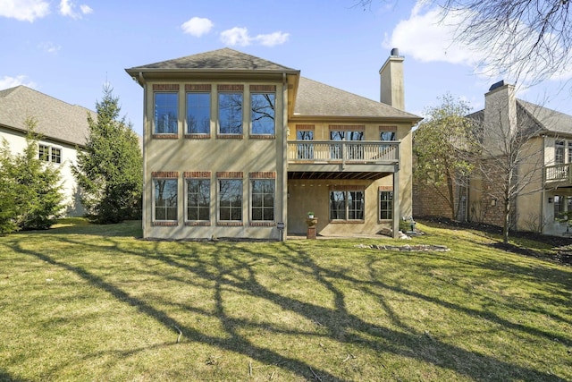 rear view of property featuring a yard, a chimney, and stucco siding