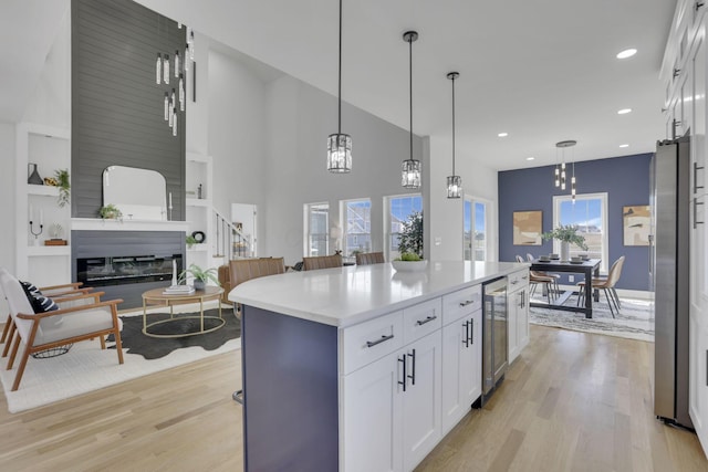 kitchen featuring light wood-type flooring, beverage cooler, and white cabinetry