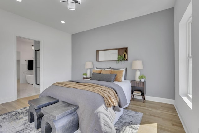 bedroom featuring recessed lighting, connected bathroom, baseboards, and light wood-style floors