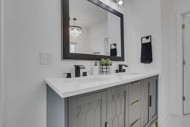 full bathroom with a sink, baseboards, marble finish floor, and double vanity