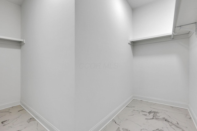 spacious closet featuring marble finish floor