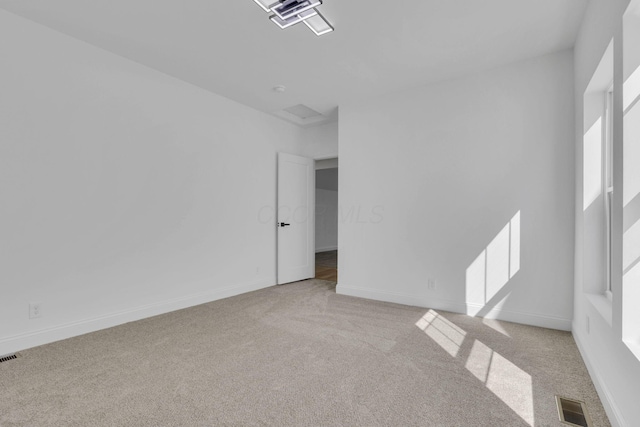 unfurnished room featuring carpet flooring, visible vents, and baseboards