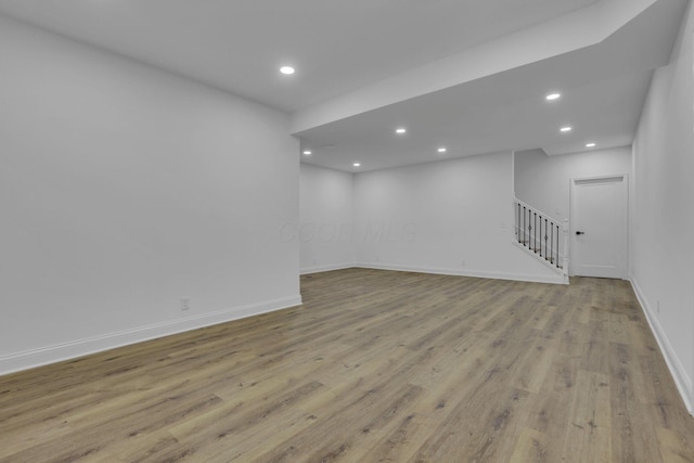 below grade area featuring stairway, recessed lighting, baseboards, and wood finished floors