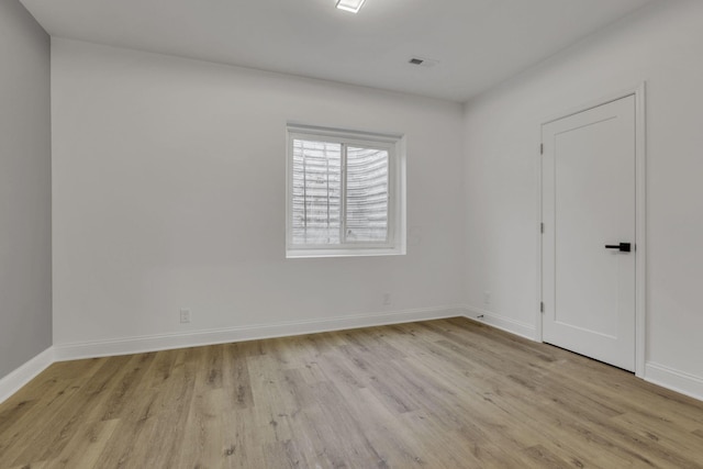 empty room with baseboards and light wood-style floors