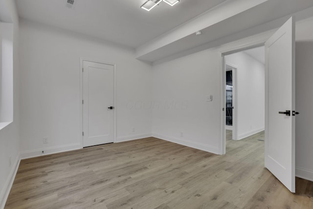 spare room featuring visible vents, baseboards, and light wood-style floors