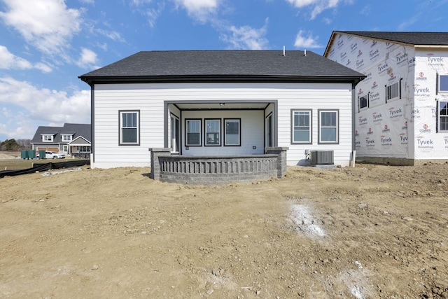 back of property featuring cooling unit and roof with shingles