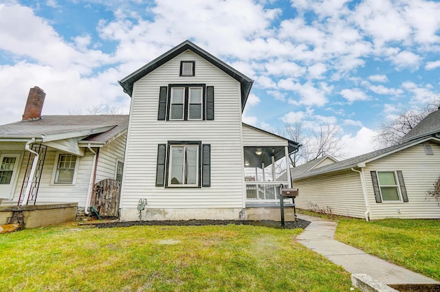 view of front of home featuring a front lawn and a sunroom