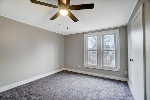 carpeted spare room featuring a ceiling fan and baseboards